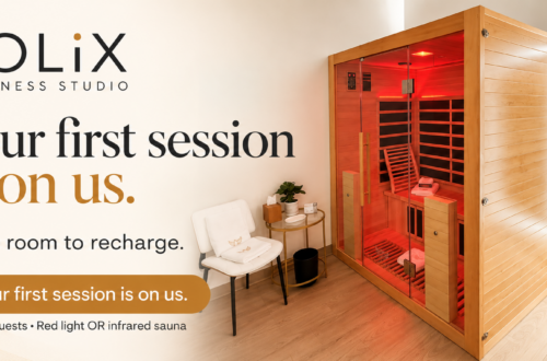 A wooden infrared sauna in a private SOLiX room, beside a chair and mirror. Campaign text: Your first session is on us. Make room to recharge.